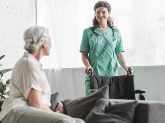 senior-woman-looking-smiling-female-nurse-with-wheelchair